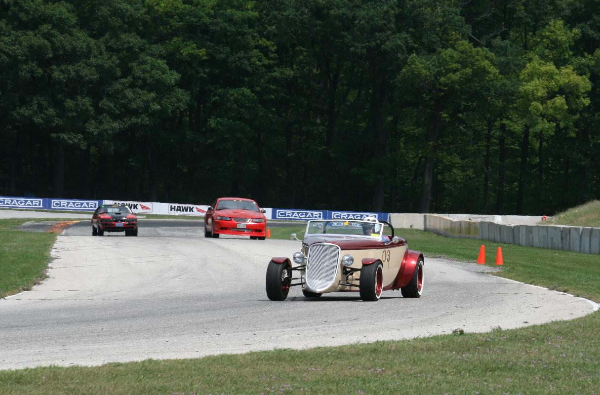 #007 BondMobile at Turn 7 Turn-in with Mustang Admirers wondering how a Hot Rod goes around corners so fast! (Northwoods Shelby Club, 2012)