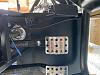 Rear brake line in DS footbox near accelerator pedal