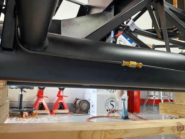 Rear brake line under DS footbox