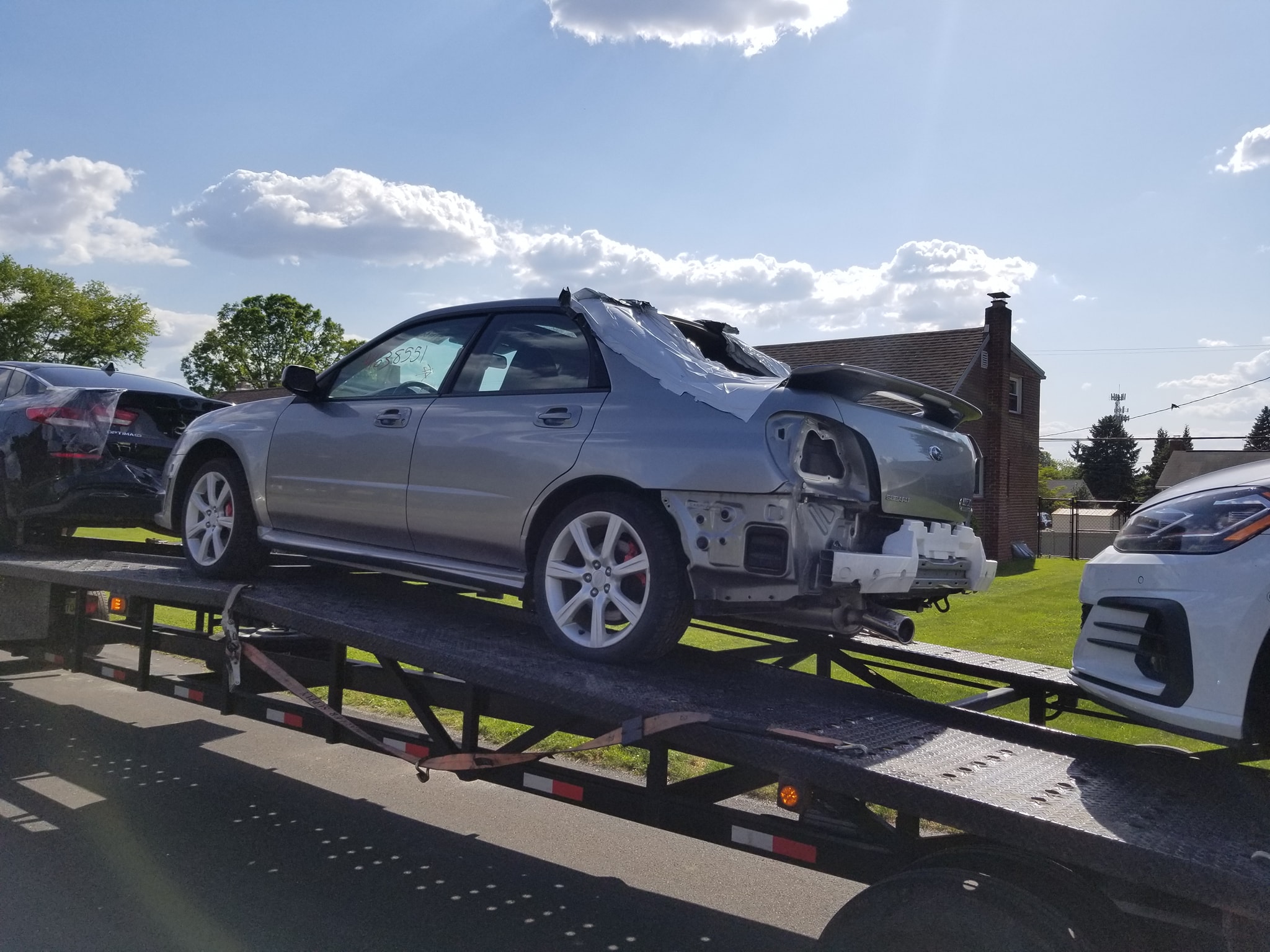 Rear window, rear bumper and passenger side skirt were inside at delivery.
