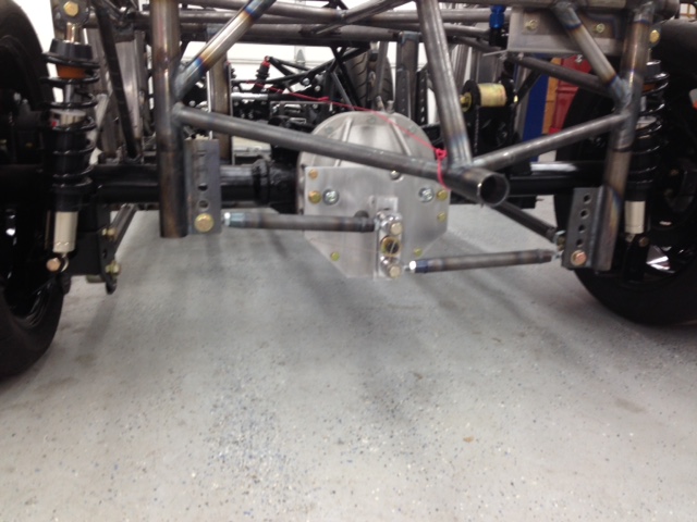 Custom watts link.  Since these designs inherently have many single point failure components the system was designed with a safety factor of 10 times the expected load.  The mounting points are designed to yield before catastrophic failure of any of the other elements.  Even then, the chassis is designed to locate the axel laterally in case of total failure.
