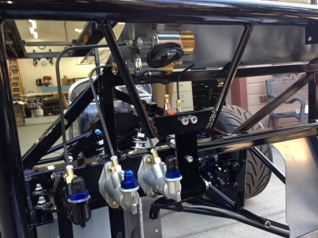 Now that the chassis is done and painted it's time to start assembling things.  After getting it on its wheels so I can roll it around the shop I started on the brake system.  In this photo you can barely make out the two 12VDC line lock solenoids.  One is for the front brake and one is for the clutch.  The clutch will be released by a delay box much like a trans brake in an auto trans car.