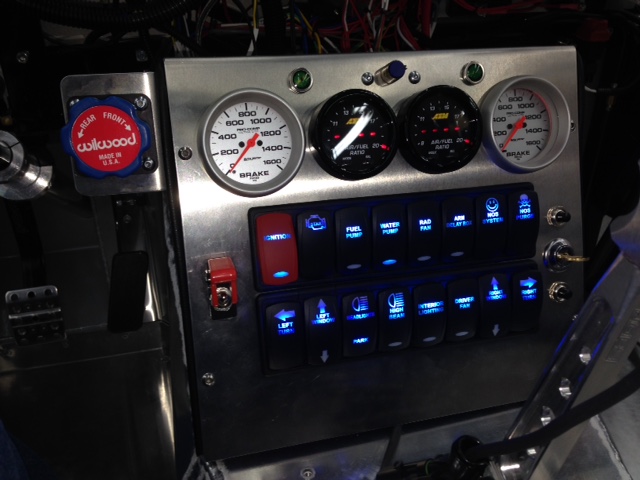 The switch and gauge panel is finally done.  The last switch actuator finally arrived after the USPS lost the first shipment.  I had to add turn signal indicators since the motorcycle turn signal box I'm using won't play nice with the RacePak display.  The turn signal control box illuminates the turn signals to approximately half normal intensity anytime there is power to the box.  This turns the signals into daytime running lights and it's a function that cannot be turned off.  That's enough voltage that the RacePak signal indicators pick it up and start flashing continuously.  So the fix that makes the most sense is to simply add LED indicators on the switch & gauge panel and disconnect the RacePak from the turn signal box.