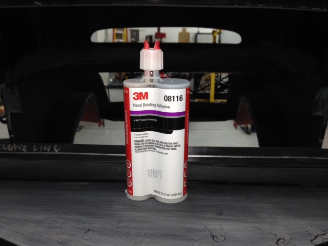 Bonded the top on with 3M panel bond.  I've always had good luck with 3M products so contacted a 3M technical expert for advice on a product they make for bonding FRP.  After his recommendation I also did some research on some Corvette sites looking for what they use to repair and modify their Tupperware bodied cars and some boating forums as well.  There were a lot of options and all had some form of issue that required a workaround.  The 3M product got good reviews but they are obviously very proud of their product as it's more expensive than others.  Since this is all new to me I figure it's a crap shoot so I put my money down and rolled the dice.  Hopefully it will be a winner but I won't know until after it's painted and been worked hard.

I was able to fit the front very close and won't need to dress up the inner parting line which would be very hard to sand and shape.  I took great pains to ensure that the nutserts I used to attach the front were securely seated in the metal imbed.  Then I also used 10ea 1/4" diameter pop rivets as a belt & suspender approach.  I made sure I got complete coverage with the panel bond here.

The rear had a 1/4" gap that I had to fill by building up layers of fiberglass using vinyl ester resin until I got the gap down to ~1/8".  Here I also used 5ea 1/4-20 nutserts to attach the rear section.  These are the type designed for fiberglass and look very similar to the kind of drywall anchors that have expanding pedals making for a much larger contact area.  Too bad there's not enough room on the front to use these as they are very solid and you'd have to break out a large portion of the fiberglass to pull them out of their mounting.
