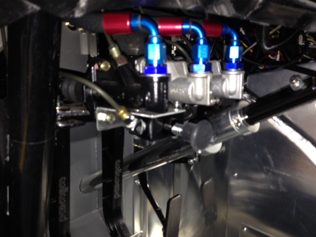 Hard to see but there is a valve mounted under the master cylinders.  This is what I'm using for a parking brake.  You step on the brake pedal and close the valve to trap pressure to the rear brakes.  The valve is designed for this purpose and is spring loaded so that it is only on when you want it on.  This allows me to run 12.19" discs and large 4-piston Wilwood calipers with 15" wheels on the rear.  I couldn't find an internal drum type parking brake that would work with the NHRA required c-clip eliminators and adding a block valve is much easier than running a parking brake handle and cables.  The goal was to run the largest rear brakes that would fit inside 15" wheels.  There are way more drag slick options for 15" wheels than 18".