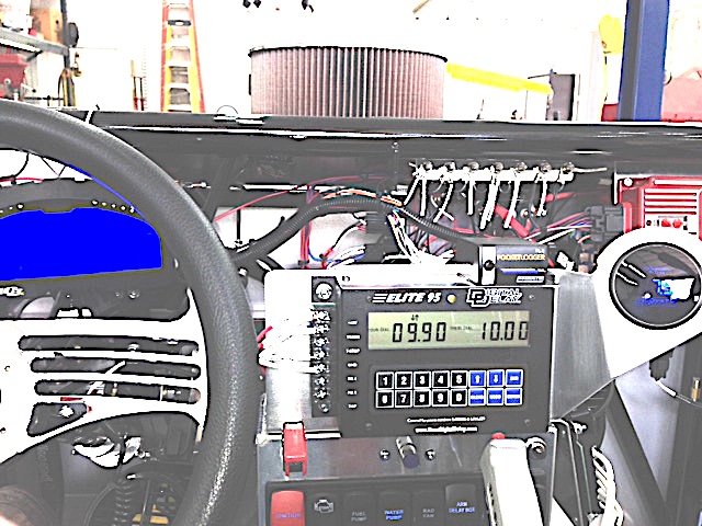 A shot of the delay box and data recorder cube that uses an SD card to record engine data.  The data recorder is not much bigger than a matchbox but will record 32 channels of data.  About anything you want to record -- turbine inlet temps, exhaust gas temp, RPM of the engine & driveshaft, speed, A/F ratio, vacuum, etc.  

The delay box is what launches the car once you release the trans brake.  The trans brake holds the trans in 1st gear & reverse at the same time so that car won't move with the throttle floored.  You release the brake button when you see the first yellow and the computer starts the countdown.  If you've programmed it right you will break the beams exactly when the green light comes on.  The car launches with about 2.5-G's so this is as close as I'll ever get to a carrier launch in an FA-18 Super Hornet.  The launch delay time can be programmed in so that you cut a good light in any condition against any opponent on a full tree.

You'll notice in some of the interior shots that many wires are exposed and not neatly run inside looms.  NHRA requires several specific circuits to be exposed, marked, and traceable by the tech inspector.  Hard to make them look neat when they can't be bundled.  Of course the dash will cover many but race cars always seem to look more "industrial" than street cars.